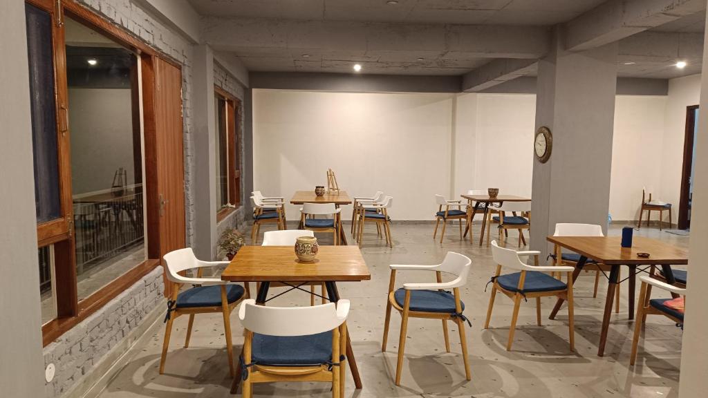 a room with tables and chairs in a restaurant at Windmill Inn in Solan