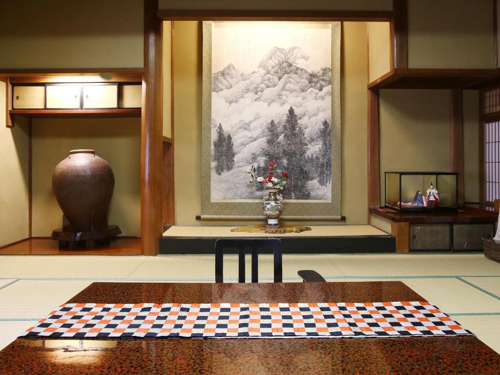 a room with a table and a painting on the wall at Kisoji no Yado Iwaya in Kiso