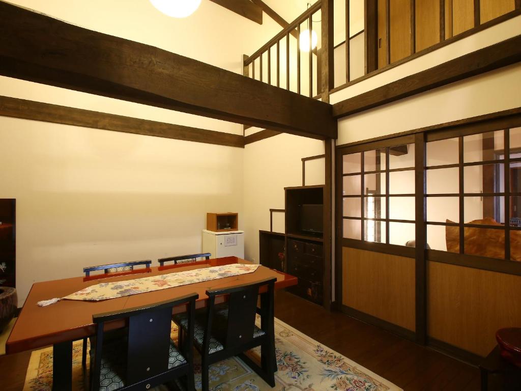 a living room with two tables and a loft at Kisoji no Yado Iwaya in Kiso