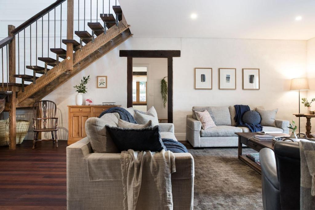 una sala de estar con 2 sofás y una escalera en Three Paddocks, en Bullarto