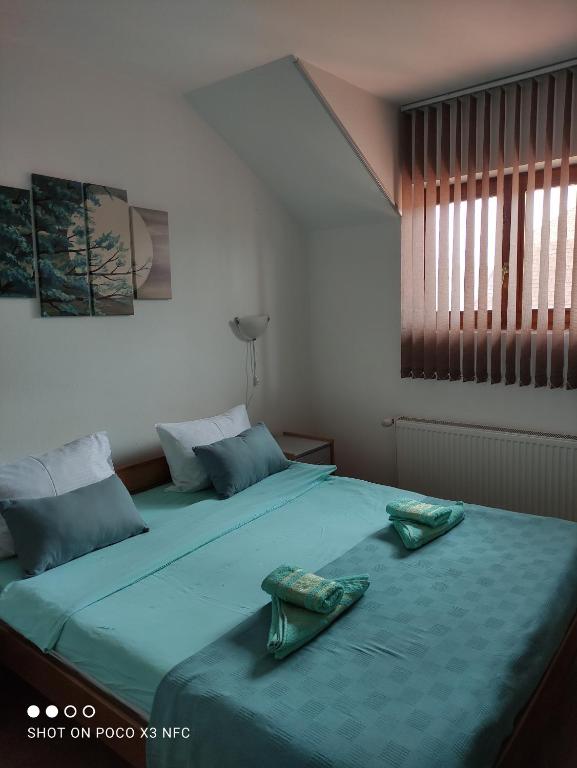 sypialnia z 2 łóżkami i zieloną pościelą w obiekcie Vila Čair DOPLATA ZA BAZEN w mieście Sokobanja