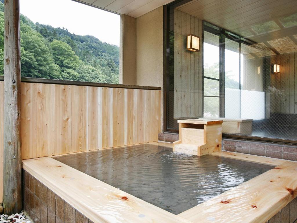 a pool of water in a room with a window at Kisoji no Yado Iwaya in Kiso