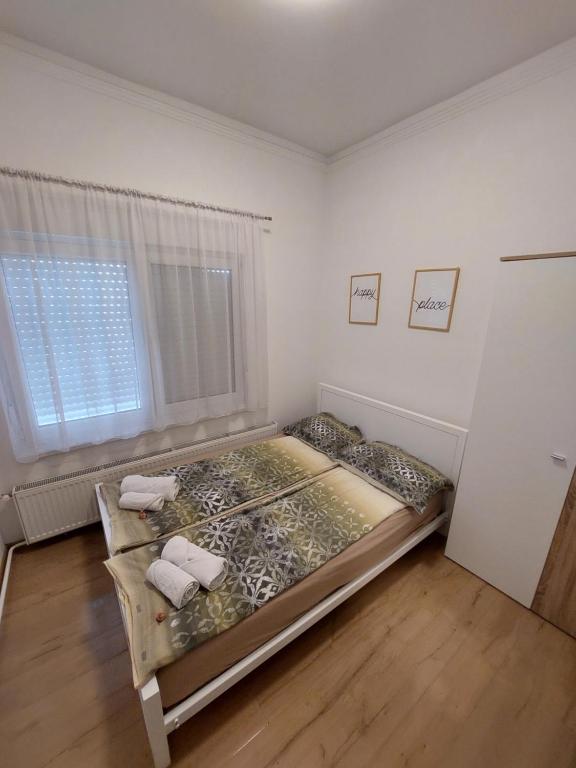 a bedroom with a bed in a room with a window at Ancora apartment Anja in Novi Sad