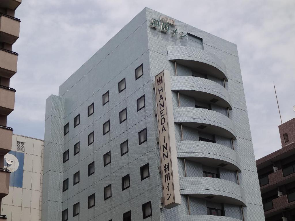 een gebouw met een bord aan de zijkant bij Haneda Inn in Tokyo