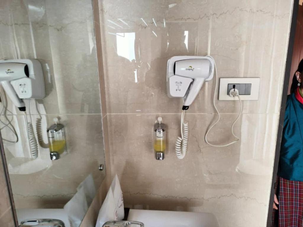 łazienka z 2 umywalkami i telefonem na ścianie w obiekcie Nirvana Inn w mieście Paro