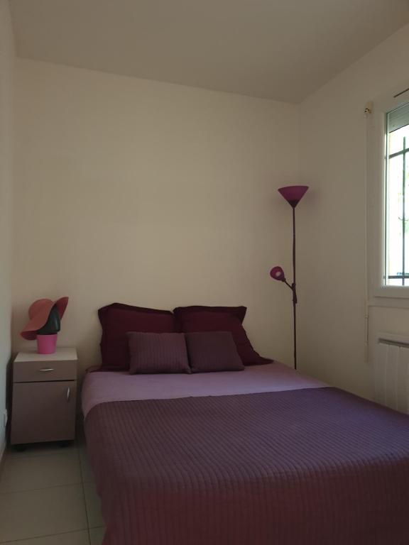 a bedroom with a bed and a lamp and a window at Villa à 10m de la plage de sable in Vallauris