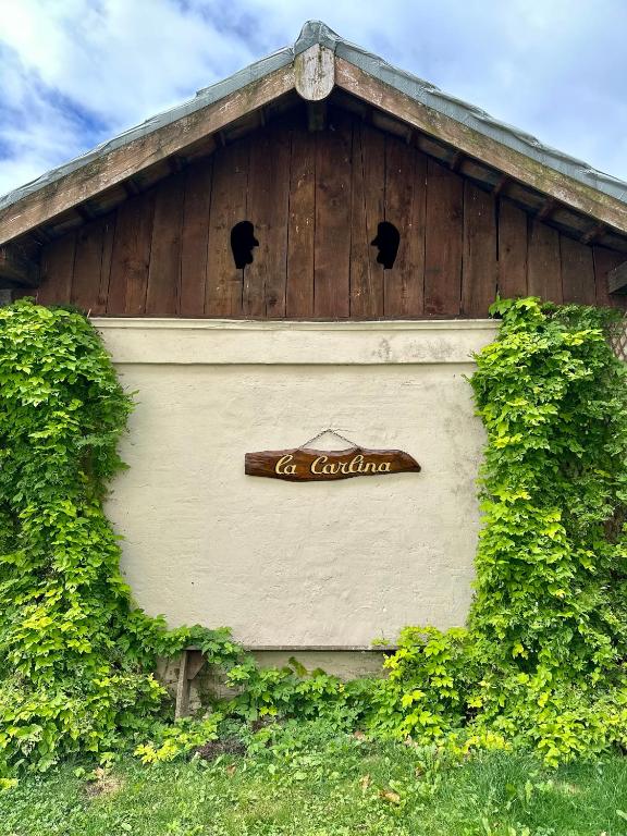 un panneau sur le côté d'un bâtiment dans l'établissement La Carlina - Loft entre lac et montagnes, à Orcier