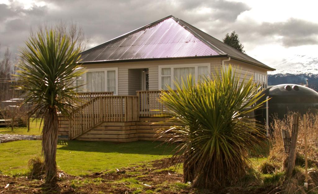 une maison avec des palmiers devant elle dans l'établissement The Mountain Pad - Rangataua Holiday Home, à Ohakune
