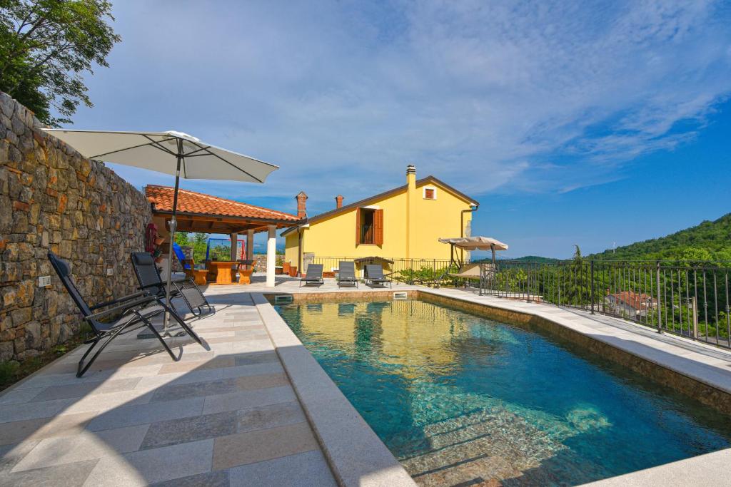 a house with a swimming pool in front of a house at Villa Danica with pool - Perka in Zvoneće