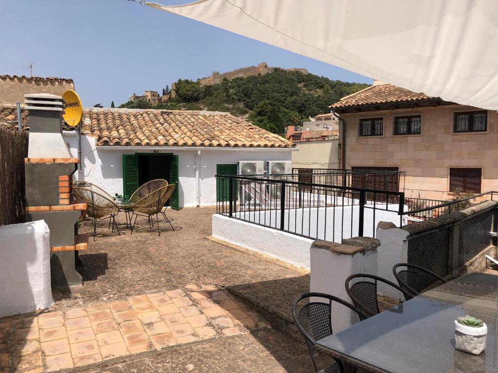 patio ze stołami i krzesłami oraz dom w obiekcie Bienvenido a Chez Matu w mieście Capdepera