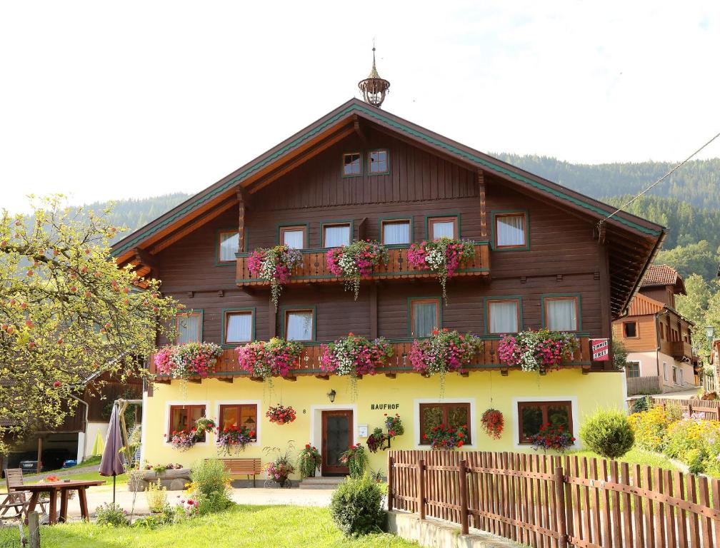 a house with flowers on the side of it at Bauernhof Haufhof Pension, Haus im Ennstal bei Schladming in Haus im Ennstal
