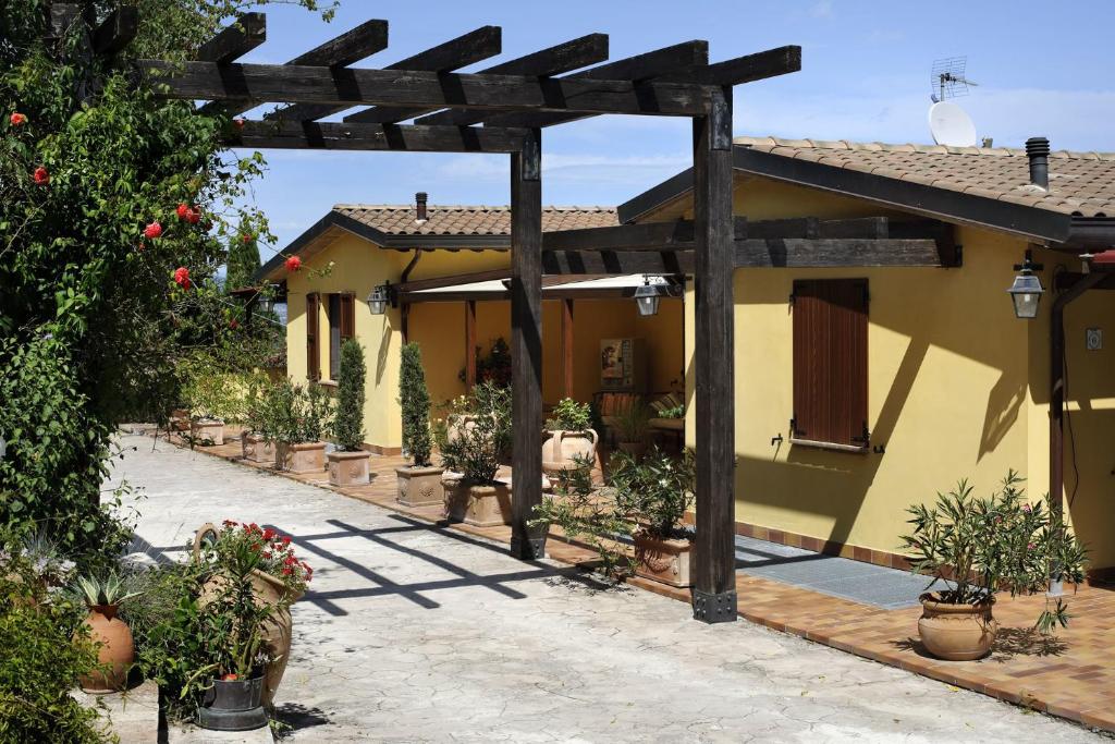 une terrasse d'une maison avec une pergola en bois dans l'établissement Country House Il Sambro, à Bettona