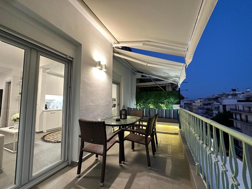 einen Balkon mit einem Tisch und Stühlen in der Unterkunft Lusso Bianco, Nilie Hospitality MGMT in Thessaloniki