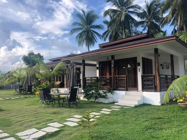 a house with a table and chairs in a yard at Villa Royal Palawan in Narra