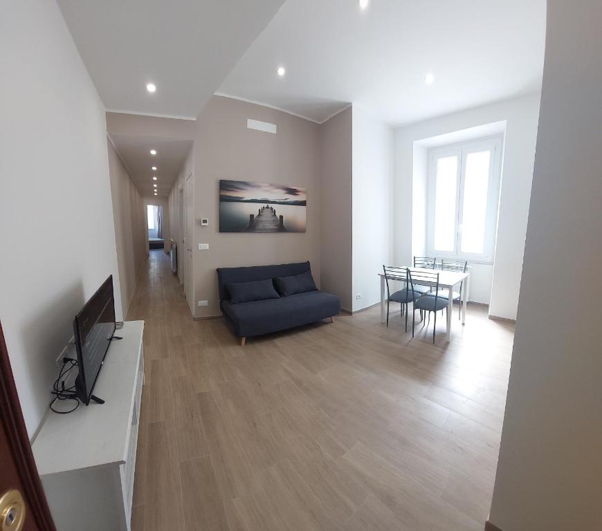 un soggiorno con divano blu e tavolo di FIUMARA MALL Apartment a Genova