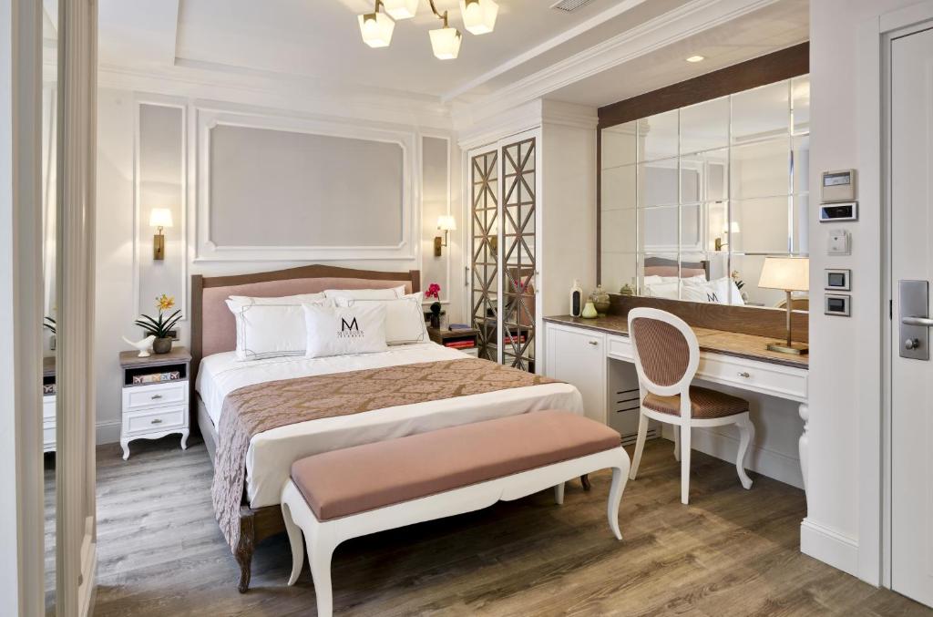 a bedroom with a bed and a desk and a mirror at Mirrors Hotel in Istanbul