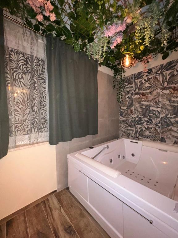 A due passi da في فورميا: حمام مع حوض استحمام و زهور على السقف