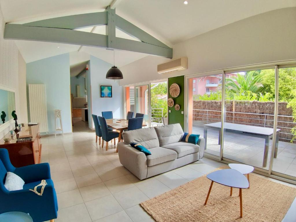 uma sala de estar com um sofá e uma mesa em Villa MAGDA à 30 mn mer pour vacances ou cure em Dax