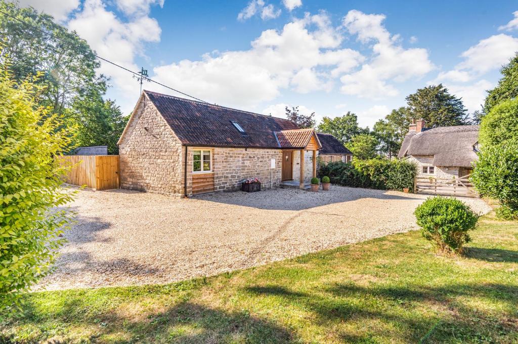 an old brick house with a gravel driveway at Old Farm Stables in Yeovil