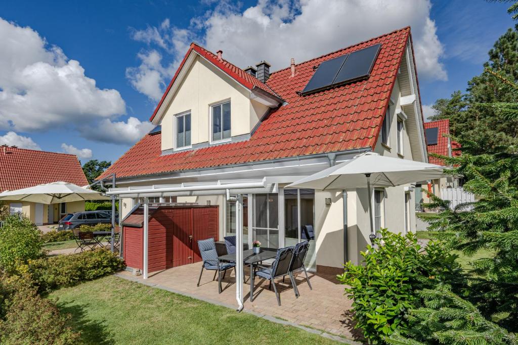 a house with a solar roof and a patio at Haus Ines in Korswandt