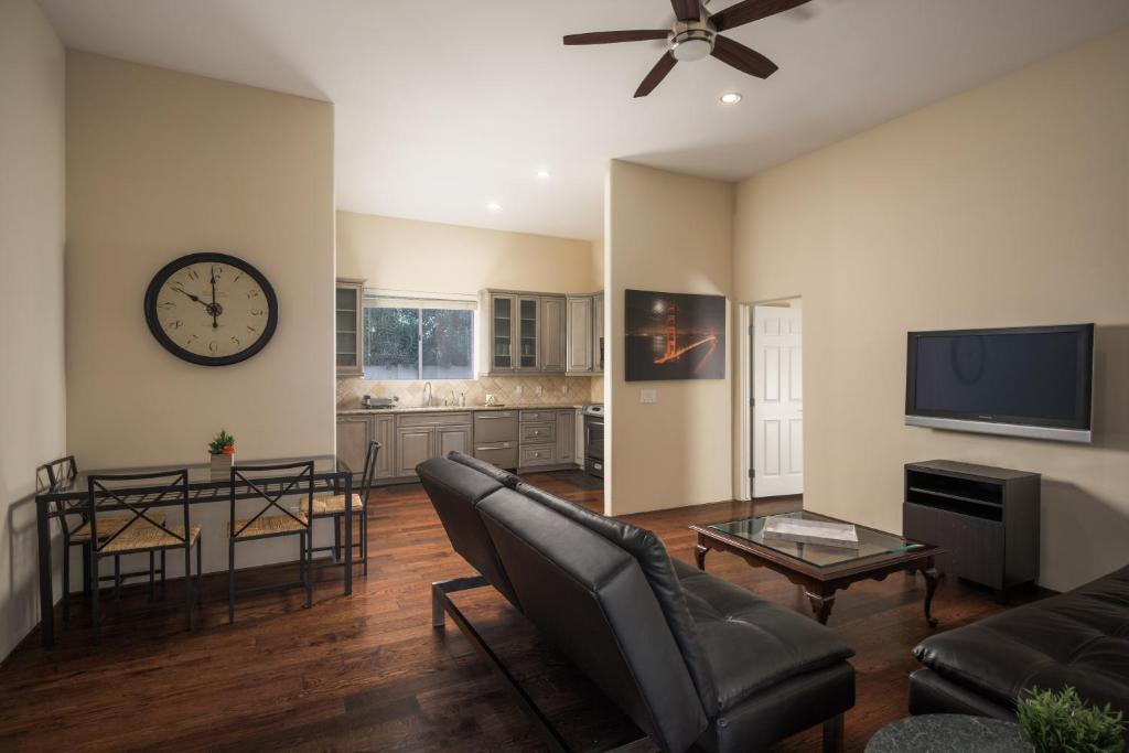 a living room with a couch and a clock on the wall at Luxury Guest House 2BA/2BR, Separate Building, Private Basketball Court, Prime Neighborhood in Scottsdale