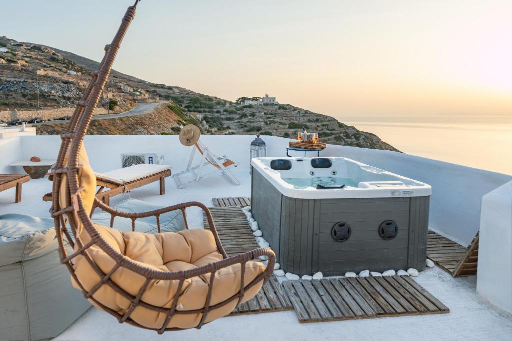 a hammock and a hot tub on the roof of a house at Paros in Síkinos