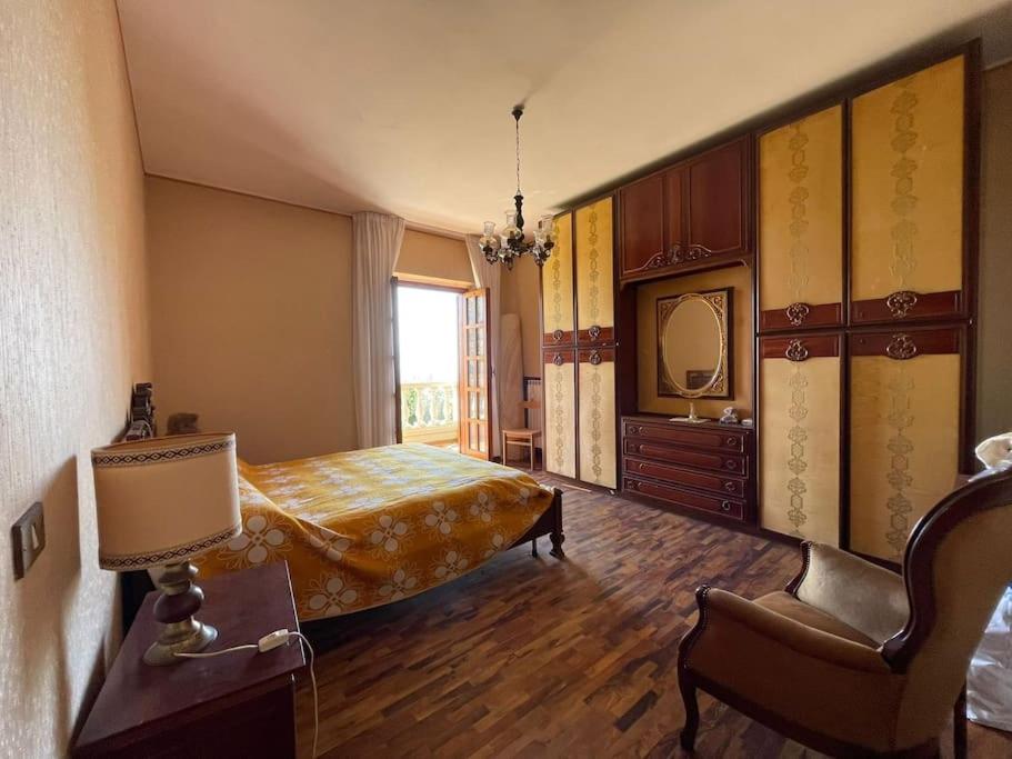 a bedroom with a bed and a chair and a mirror at Casa dei nonni in Alba Adriatica