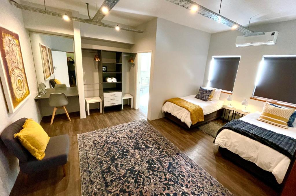 a bedroom with two beds and a mirror at Zeederberg Corner in Paarl