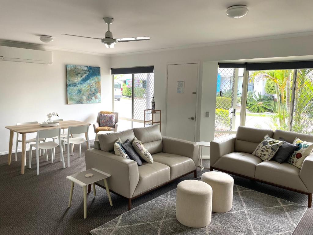 ein Wohnzimmer mit einem Sofa und einem Tisch in der Unterkunft 2 Bedroom Villa In Tropical Resort in Noosaville