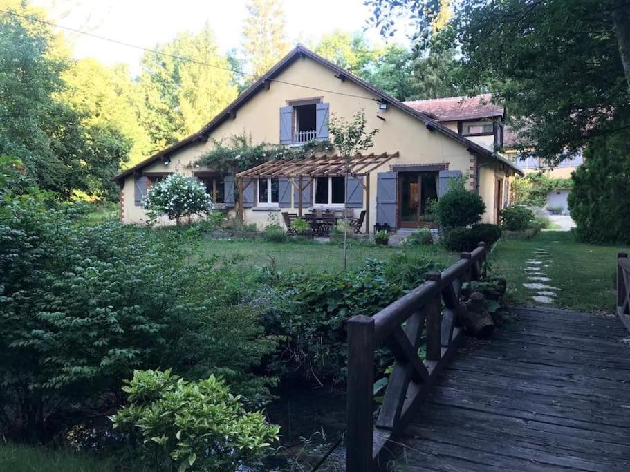 une maison avec un pont en bois devant elle dans l'établissement Charming country house in the forest, with heated pool, à Cerdon