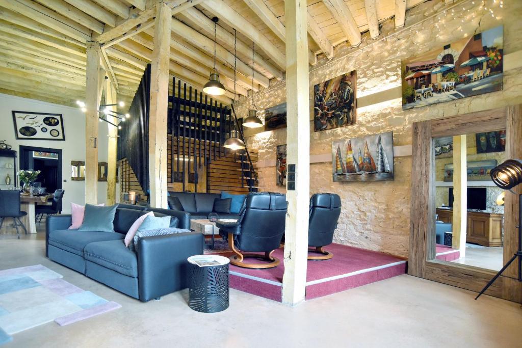 un salon avec un canapé bleu et des chaises dans l'établissement Galerie - Ancienne galerie de peinture sur le port, à Dinan