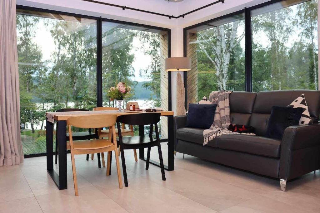 a living room with a couch and a table and chairs at Pokój kapitański in Polańczyk