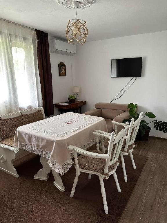 a living room with a table and chairs and a couch at Къща за гости Ива 
