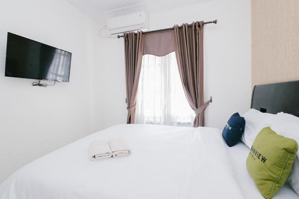 Postel nebo postele na pokoji v ubytování Urbanview Hotel Sultan Palace Malang by RedDoorz