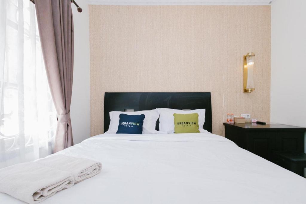 Postel nebo postele na pokoji v ubytování Urbanview Hotel Sultan Palace Malang by RedDoorz