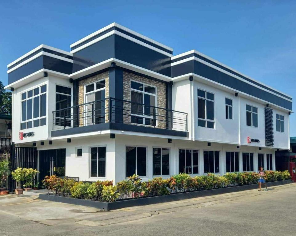 um edifício branco com um telhado preto em GLC SUITES em Bislig