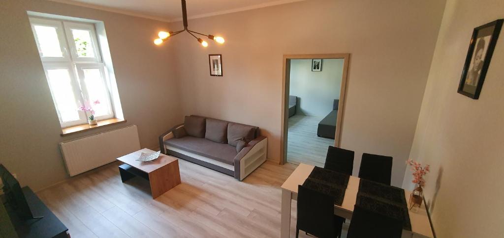 uma sala de estar com um sofá e uma mesa em Apartament Starówka em Konin