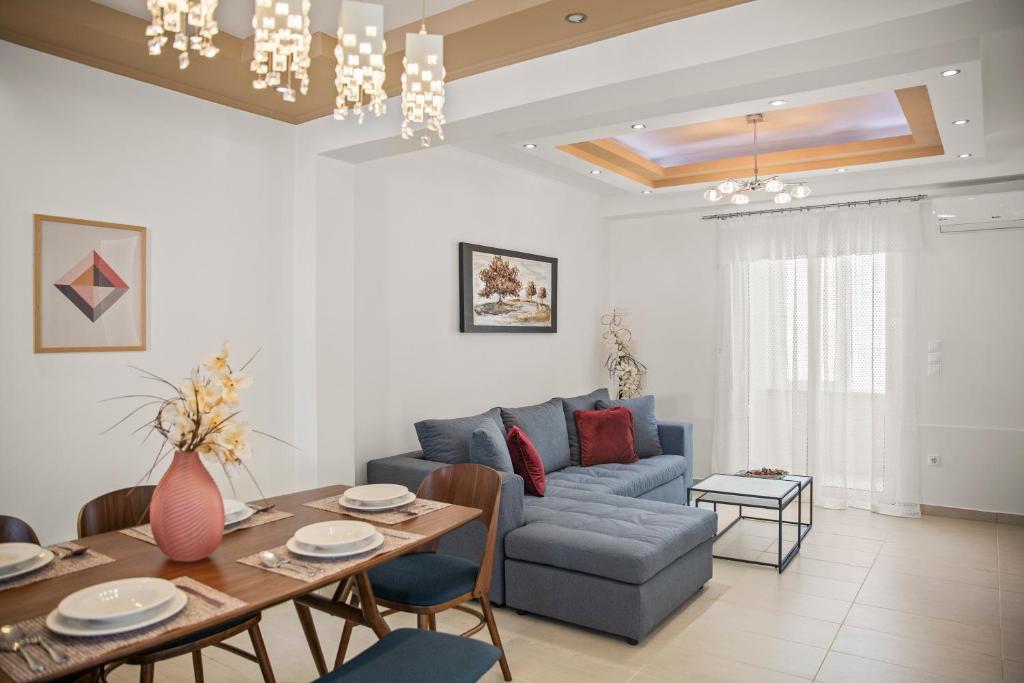 a living room with a table and a blue couch at Rhodian Filoxenia in Rhodes Town