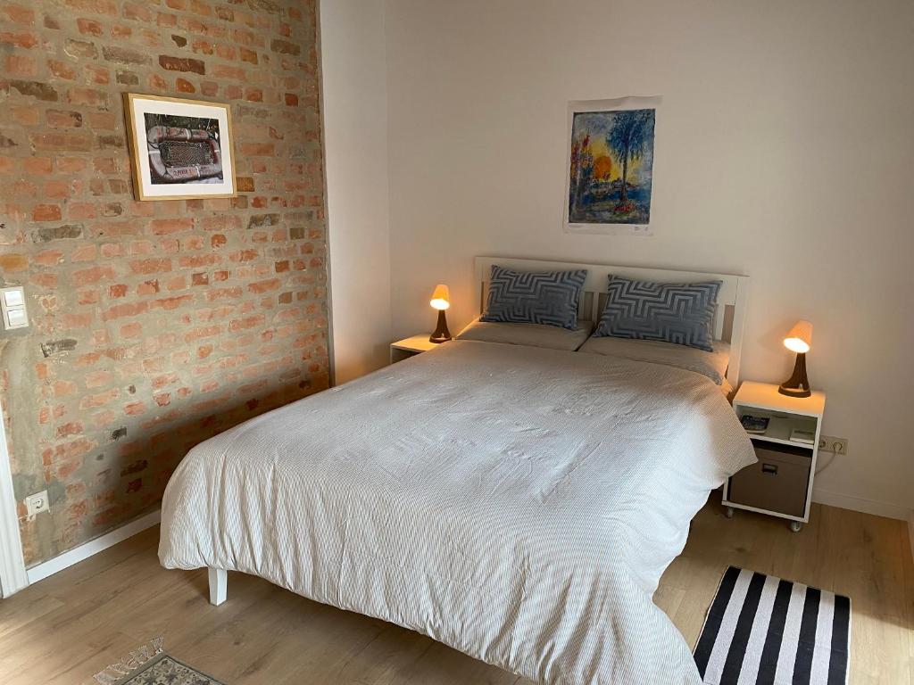 a bedroom with a bed and two lamps on two tables at Mikroapartment Leipzig in Leipzig