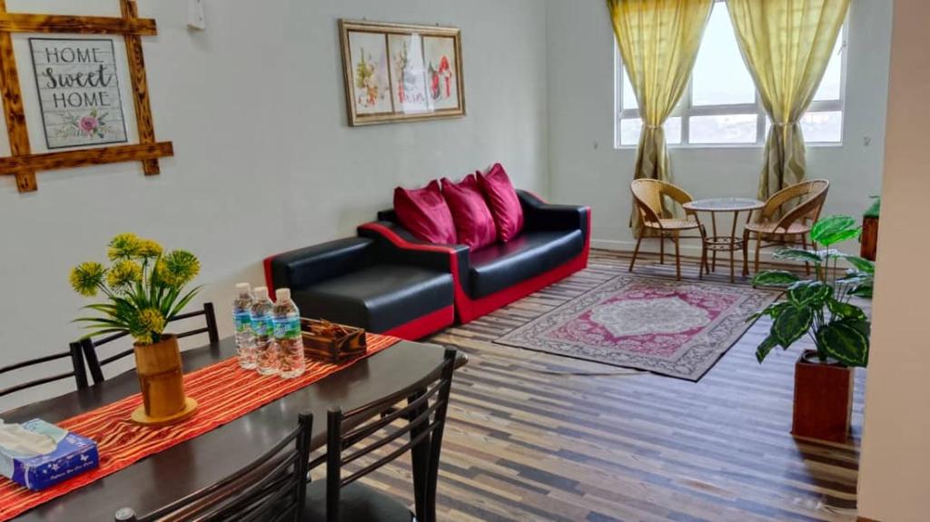 a living room with a couch and a table at Homestay Camelia Kuala Terengganu - Near Drawbridge, Pasar Payang, KTCC Mall, Hospital HSNZ and Batu Buruk Beach Area in Kuala Terengganu