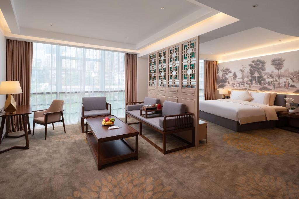 Habitación de hotel con cama y sala de estar. en Guangzhou Wogo Yuanbao Hotel - Zhujiang New Town with free coffee en Guangzhou