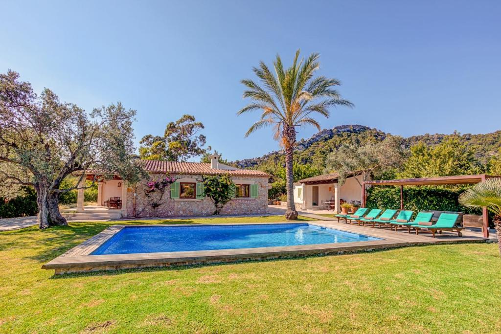 un patio trasero con piscina y una casa en Villa Can Gallardo, en Pollensa