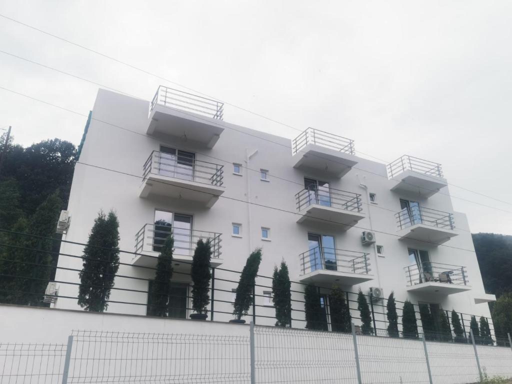 un edificio blanco con balcones y una valla en Vila AMAZON, en Dubova