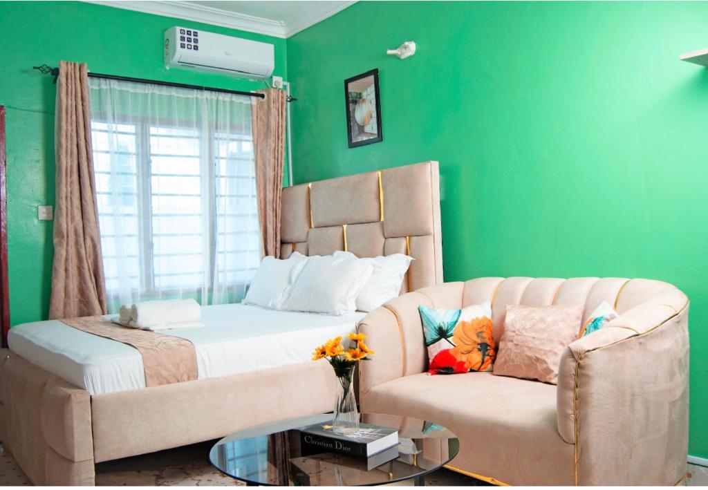 a green bedroom with a bed and a couch at Emap Homes- Golf studio in Kilifi