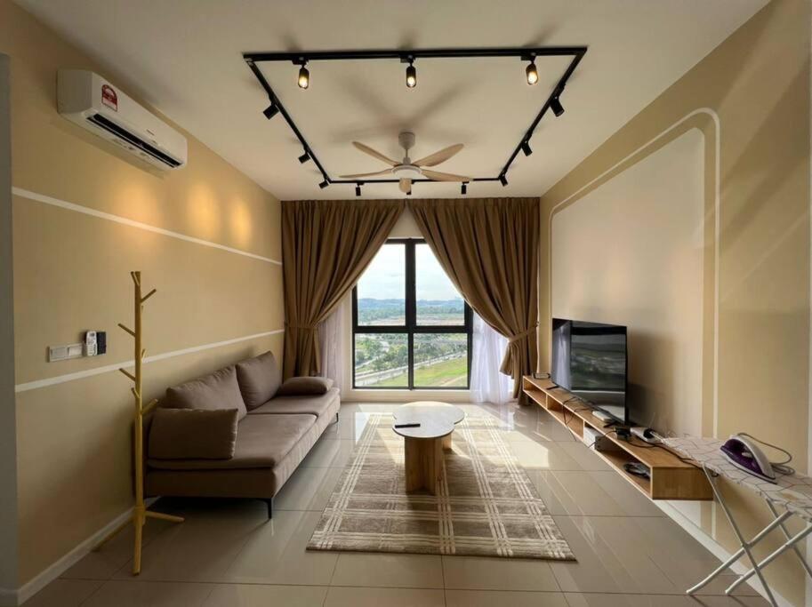 ein Wohnzimmer mit einem Sofa und einem TV in der Unterkunft The Clio 2 IOI Resort City, beside ioi city mall, serdang hospital, upm and uniteen in Putrajaya