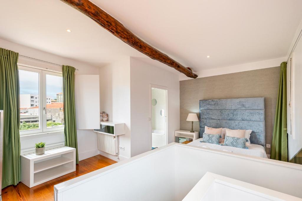 um quarto com uma cama grande e 2 janelas em Your OWM Porto no Porto
