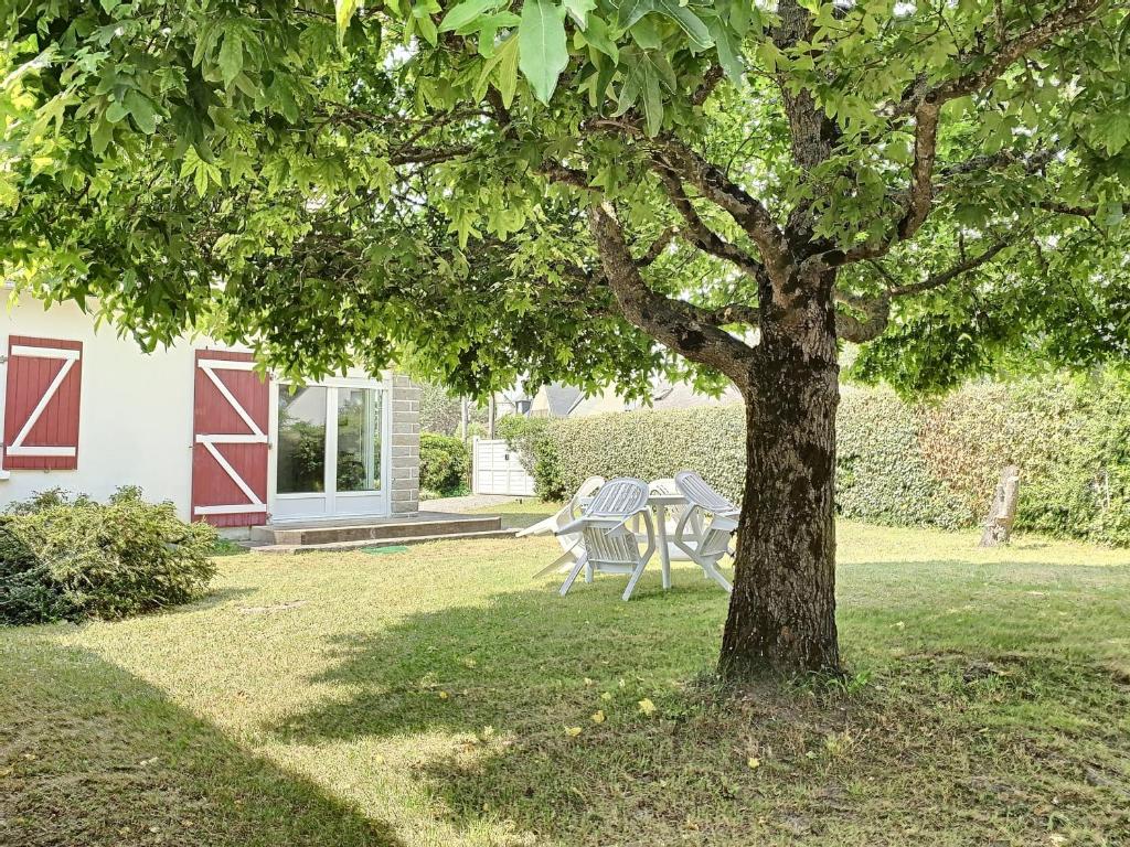 un arbre devant une maison avec une table et des chaises dans l'établissement Maison de vacances avec jardin clos à 150m de la plage, idéale pour familles - FR-1-361-389, à Saint-Pair-sur-Mer
