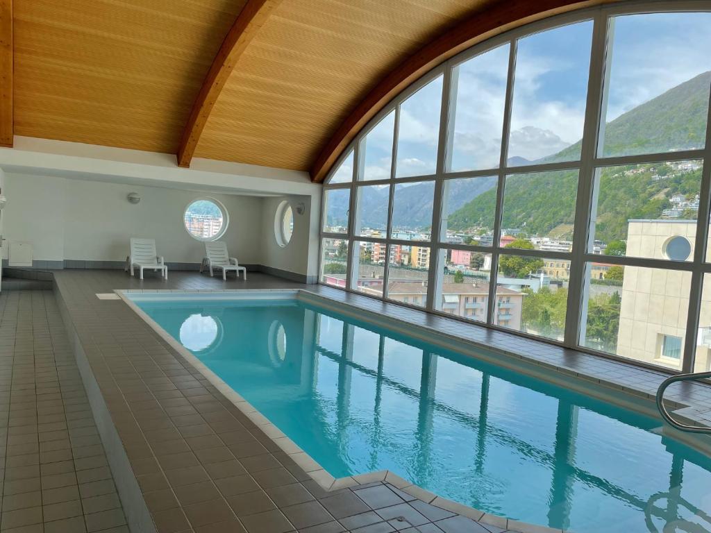 Appartamento 464 nel CUORE di Locarno con piscina في لوكارنو: مسبح مطل على الجبال
