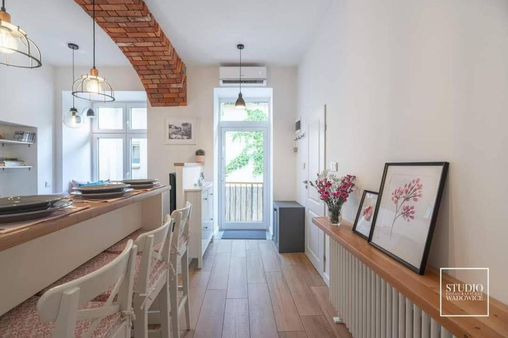 a kitchen with a long counter and a dining room at N-apartament Wadowice in Wadowice