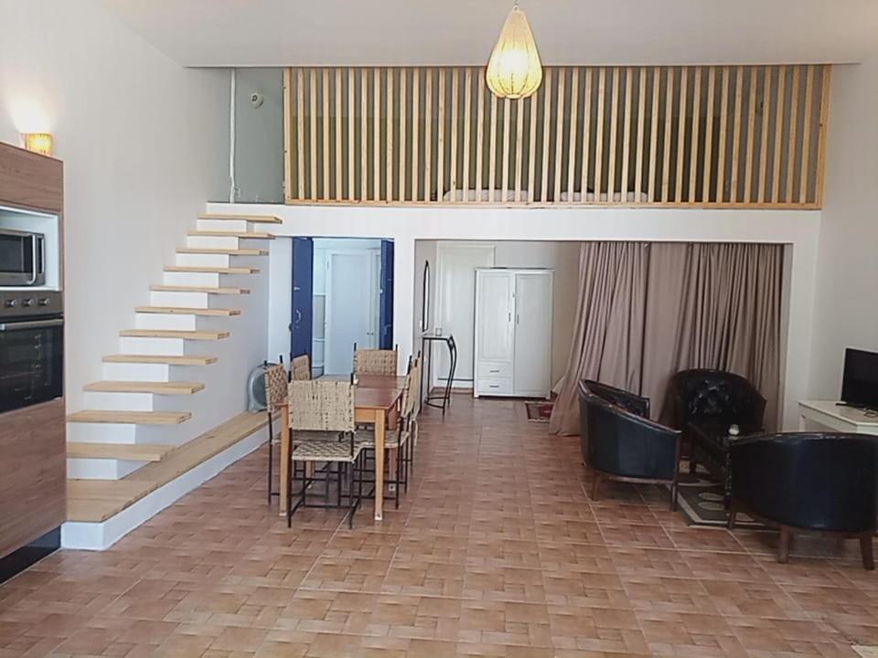 une chambre avec un escalier, une table et des chaises dans l'établissement Auberge du Marabout, à Sidi Kaouki